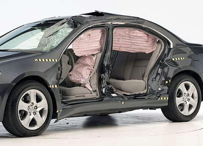 Вид автомобиля после краш-теста со снятыми дверьми, где видны боковые подушки безопасности и повреждения пассажирского салона