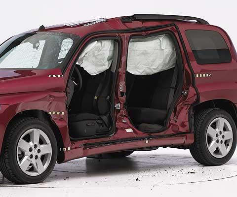 View of the vehicle after the crash with doors removed, showing the side airbag and damage to the occupant compartment