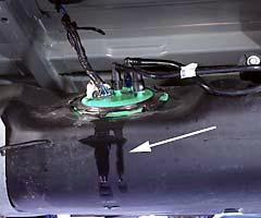 In the second test, a large amount of the fluid in the fuel system leaked from a circular fitting (green plastic) on top of the fuel tank. Leaking fluid is visible (arrow) running down the side of the black plastic fuel tank
