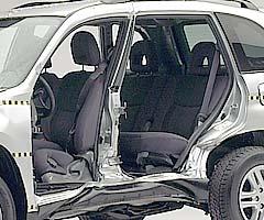 View of the vehicle after the crash with doors removed, showing the side airbags and damage to the occupant compartment